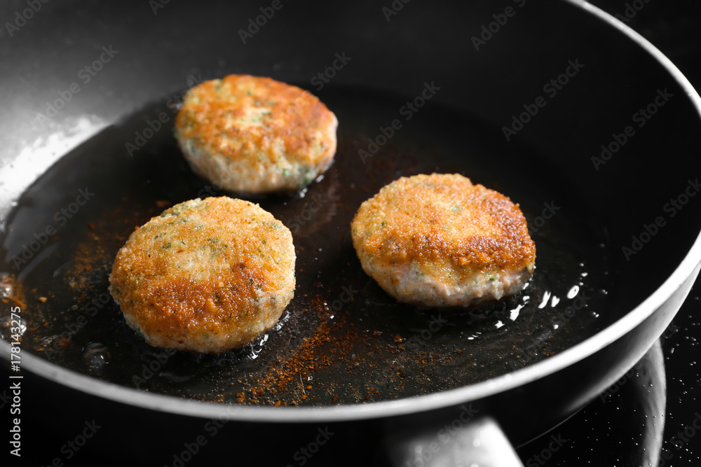 Salmon patties frying on pan, closeup