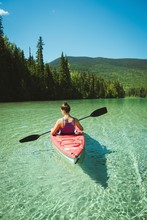 Rear View Of Woman Kayaking In River