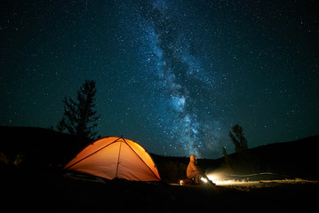 tourist near his camp tent at night.