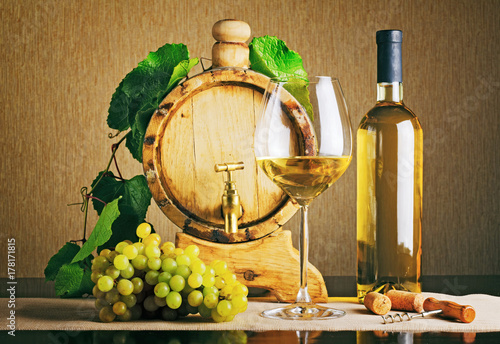 Plakat Drewniana beczka na wino z gałązką winogronową. Butelka białego wina