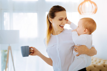 positive mother drinking tea with her child