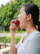 © zilvergolf - Side view of young asian girl eats an apple.