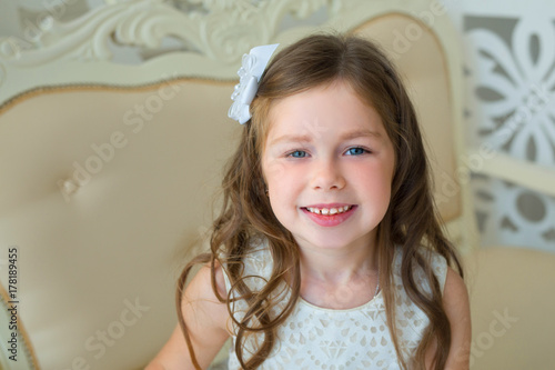 Plakat piękne młode radosne dziecko dziewczyna w eleganckiej sukience we wnętrzu