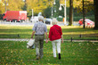 © scharfsinn86 - A loving elderly couple is walking in the park. Senior people holding hands. Back view.