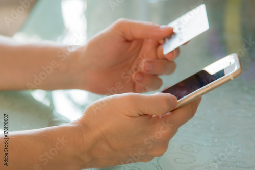 Zdjęcie XXL Internetowa bankowość w żeńskich rękach przeciw tłu szklany stół
