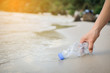 © sawitreelyaon - Hand woman picking up plastic bottle cleaning on the beach , volunteer concept