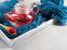 Raspberry Tea In Glass Teapot On Gray. Healthy Hot Drink