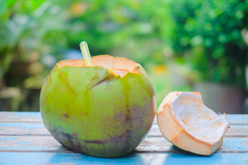 Fresh Coconut with  straw on old wood with blurred background