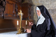 Nun lighting altar candles