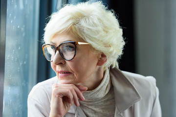 Wall Mural - senior lady looking through window