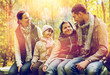 © Syda Productions - happy family sitting on bench and talking at camp
