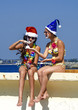 © kravik93 - Two girlfriends in a Santa hat and in the image of a pirate during a beach holiday.