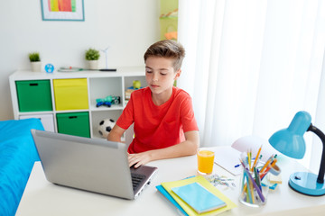 Canvas Print - student boy typing on laptop computer at home