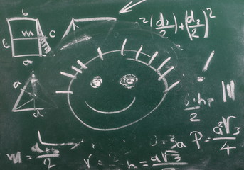 Mathematical equation and smiley face on chalkboard, blackboard texture