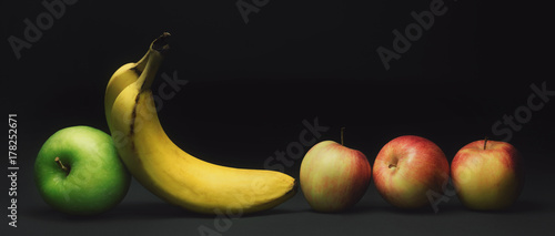 Zdjęcie XXL Owoc z rzędu, jabłka i banany odizolowywający na czerni