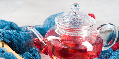 Plakat Malinowa herbata w szklanym teapot na szarość. Zdrowy gorący napój