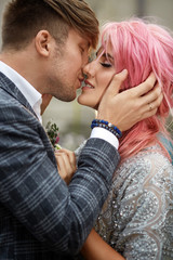 A moment before a kiss between woman with pink hair and her handsome man