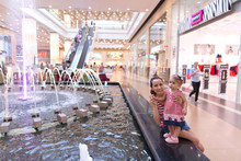 Mother And Baby Girl In A Shopping Center At The Fountain