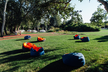 many colorful soft beanbag seats on grass