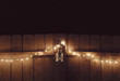 © Rachel Bellinsky/Stocksy - Christmas lights draped on a fence at night with lantern