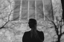 Black And White Silhouette Of Girl In Front Of Brick Building