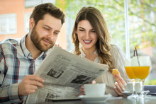 A Young Couple Reading The Newspaper