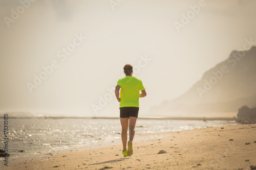 Plakat Jogging na tropikalnej, piaszczystej plaży w pobliżu morza / oceanu.