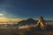 © astrosystem - Girl watching the sunrise from mount Batur, Bali - Indonesia.