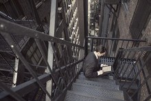 Retro Look Man In Suit Using Tablet In New York Old Building Fire Escape Stairs