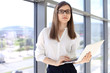© volha_r - Modern business woman typing on laptop computer while standing in the office before meeting or presentation