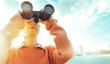 © tinyakov - Beautiful Young Girl Looking Through Binoculars At The Sea On A Bright Sunny Day. Travel Holidays Journey Concept