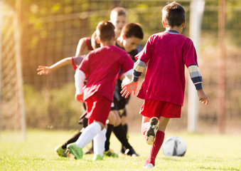 Wall Mural - Kids soccer football - children players match on soccer field