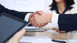 © rogerphoto - Close up of business people shaking hands at meeting or negotiation in the office. Partners are satisfied because signing contract