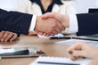 © rogerphoto - Close up of business people shaking hands at meeting or negotiation in the office. Partners are satisfied because signing contract