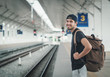 Young traveler walking with backpack on train station