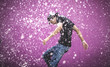 © Mint Images - Young man standing in shower of water drops