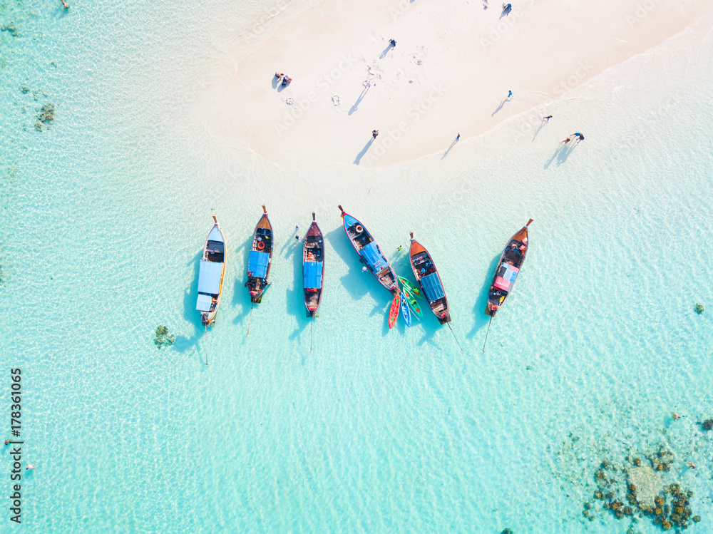Top view or aerial view of longtail boats on crystal clear water along the sand beach in Phuket Thailand - obrazy, fototapety, plakaty 