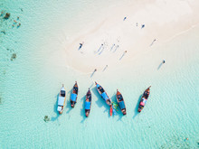 Top View Or Aerial View Of Longtail Boats On Crystal Clear Water Along The Sand Beach In Phuket Thailand