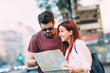 © minastefanovic - Young couple traveler lost in the city using map