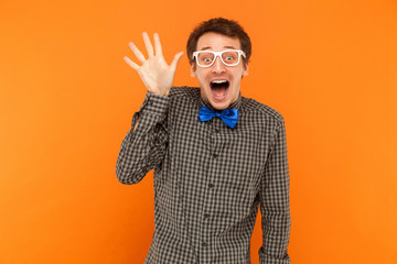 Well hi! Young adult crazy man toothy smiling and showing hand at camera