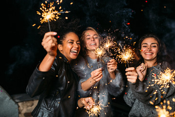 Wall Mural - Young friends enjoying with sparklers at night