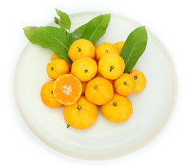 Orange fruit with leaves on white plate isolated on white background.