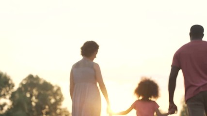 Wall Mural - Three person family slowly walking into the sunset, happy future together