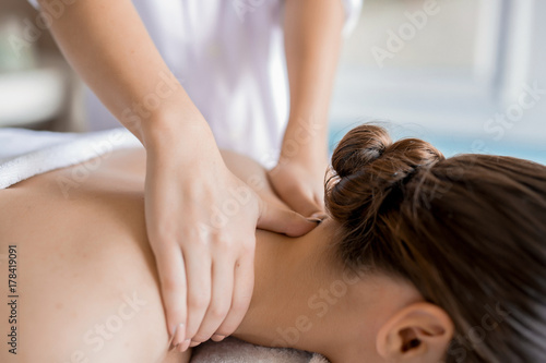 Fotografía Hands of masseuse massaging neck and shoulders of relaxed client in spa salon