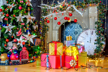 christmas background, a lot of boxes with gifts lies near the festive christmas tree, in the backgro