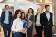 © mast3r - Hotel Administrator Welcome Business People In Lobby, Mix Race Businesspeople Group Guests Arrive Entrance With Suitcase
