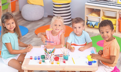 Canvas Print - Cute children painting at table indoor