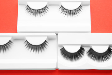 Wall Mural - Different false eyelashes in packs on color background