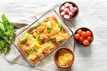 Canvas Print - Composition with delicious sausage casserole in baking dish on table