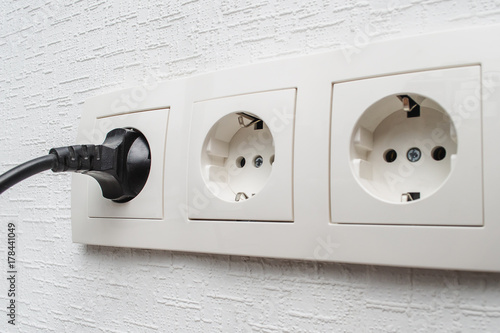 Fotografía European set outlet on the wall with the plug inserted